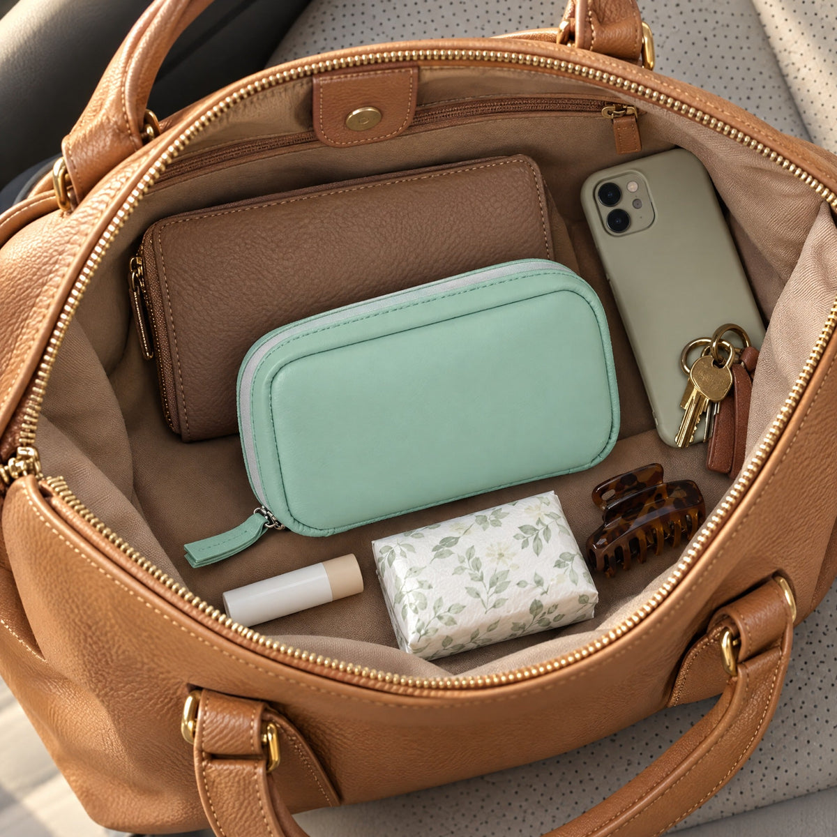 Daypouch zip case inside a handbag next to a wallet and phone